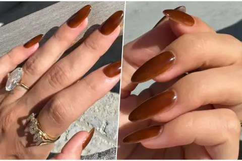 Manucure marron élégante sur des ongles longs et pointus, ornés de bagues scintillantes.