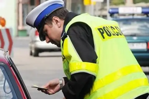 Policjant wręcza mandat. Zastanawiasz się, co jeśli nie zapłacę mandatu w ciągu 7 dni? Lepiej tego nie sprawdzać.