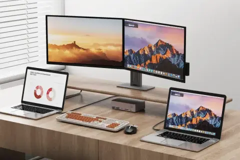 Dwa monitory i dwa laptopy na biurku. Dowiedz się, jak podłączyć dwa monitory do laptopa, aby zwiększyć produktywność.