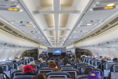 Wnętrze samolotu Ryanair Boeing 737-800. Widok na rząd siedzeń i pasażerów.