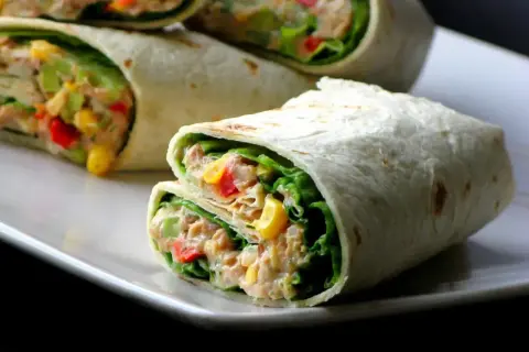 Pyszna tortilla z tuńczykiem, chrupiącą sałatą, kukurydzą i papryką. Idealna na szybki lunch.