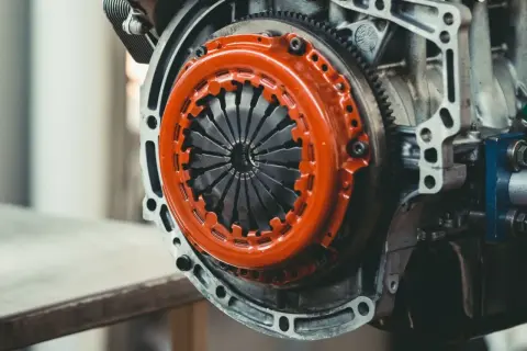 Mechanizm sprzęgła z pomarańczową osłoną. Zastanawiasz się, ile kosztuje wymiana dwumasy?