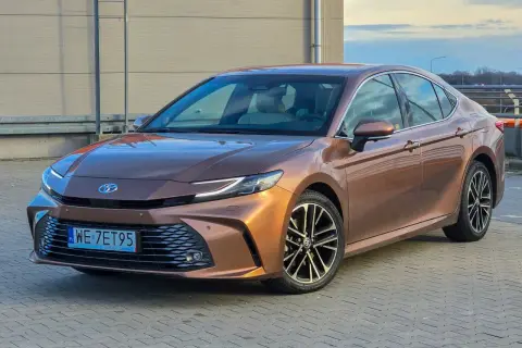 Brązowa Toyota Camry 2.5 Hybrid prezentuje się elegancko, a jej niskie spalanie to atut dla kierowców.