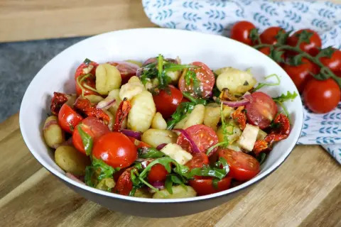 Leckerer Gnocchi Salat mit Kirschtomaten, getrockneten Tomaten, roter Zwiebel und Rucola. Ein leichter Genuss!