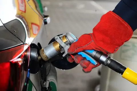Ręka w czerwonej rękawicy podłącza pistolet do tankowania LPG. To proste tankowanie dla początkujących.