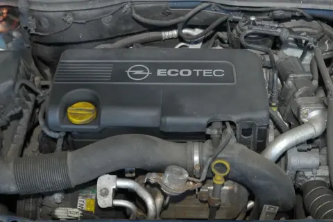 Silnik Ecotec w Oplu Astra 3. Widoczna pokrywa silnika, przewody i akumulator.