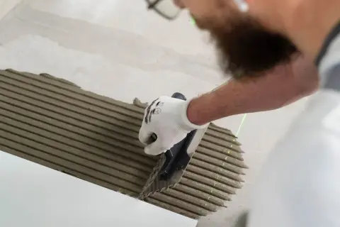 Pose d'enduit pour carrelage au sol. Le temps de séchage carrelage sol est crucial pour une pose réussie.