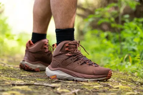 Scarpe da hiking: il loro significato è avventura e comfort su ogni sentiero. Stivali marroni su un sentiero nel bosco.