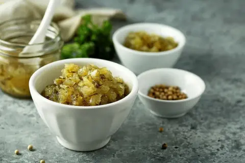Smakfull bostongurka i skålar, redo för ditt nästa recept. En burk med inlagd gurka och kryddor i bakgrunden.