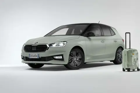 La Skoda Fabia 2026, color verde pastello con tetto nero, è pronta per un viaggio. Accanto, una valigia verde con la scritta "Find your way".