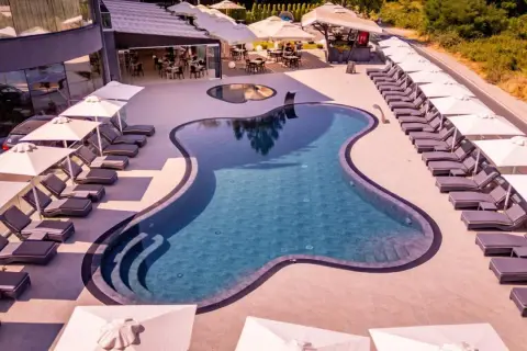 Relaks przy basenie w Laki Hotel & Spa. Leżaki i parasole czekają na gości.