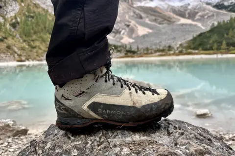 Buty Garmont Vetta GTX na kamieniu, z widokiem na turkusowe jezioro i góry. Gotowe na każdą wyprawę.