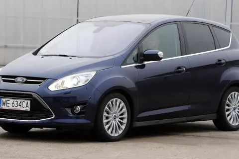 Ciemnoniebieski Ford C-Max, popularny wśród rodzin, widziany z boku. Wiele osób szuka ford c max opinie przed zakupem.