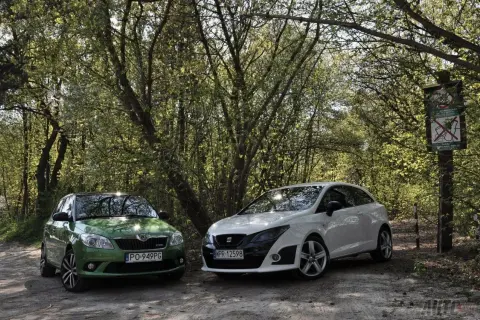 Zielony Skoda i biały Seat Bocanegra na leśnej drodze.
