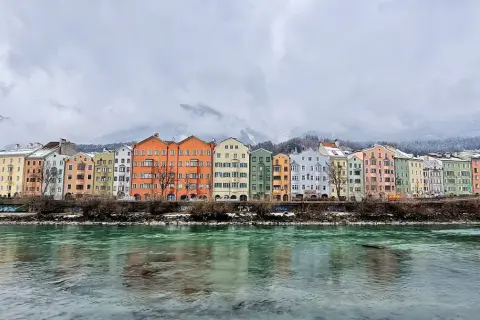 Kolorowe kamienice nad rzeką Inn, w tle ośnieżone góry. Idealne miejsce, by zobaczyć Innsbruck.