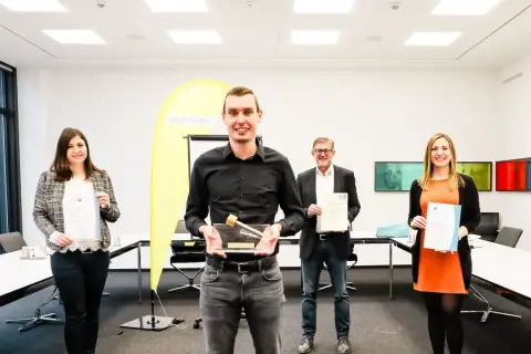 Glückliche Absolventen mit Urkunden und Pokal. Gute Aussichten für die Elektroniker Ausbildung Gehalt Bayern.
