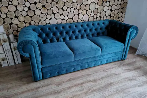 Elegancka kanapa chesterfield w kolorze turkusowym, idealna do salonu. To przykład wysokiej jakości produkcji mebli tapicerowanych.