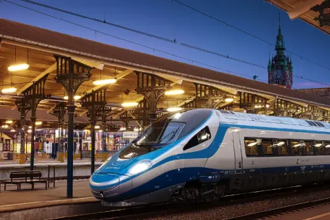 Nowoczesny pociąg EIP PKP Intercity na tle zabytkowego dworca w Gdańsku.