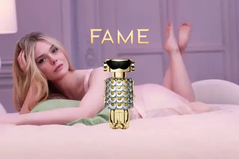 Elle Fanning w łóżku z flakonem perfum FAME Paco Rabanne.
