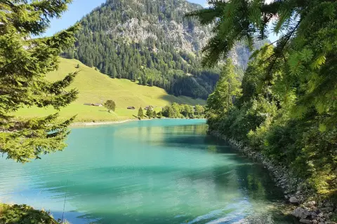 Türkises Wasser und grüne Hänge im Liechtenstein. Die Natur lädt zum Verweilen ein.