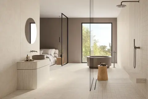 Élégante salle de bain beige et noir avec baignoire, douche, lavabo et lit. Un espace moderne et épuré.