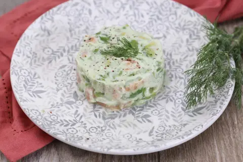 Délicieux tartare de saumon avocat, garni d'aneth frais et servi sur une assiette ornée.