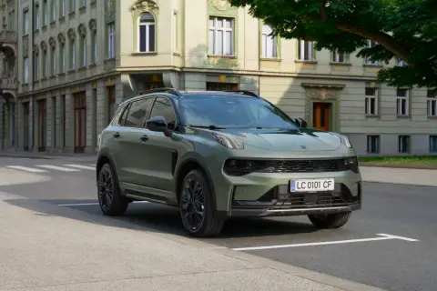 Zielony Lynk & Co SUV zaparkowany na ulicy przed zabytkową kamienicą.