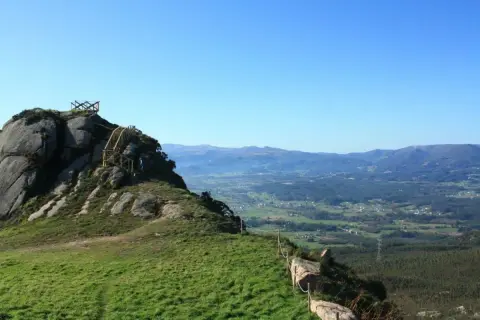 Ascenso al Pico da Frouxeira, con escaleras de madera y vistas panorámicas de valles verdes y montañas.