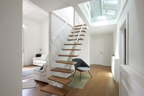 Scala interna moderna in legno e metallo, con design a sbalzo. La normativa scale interne uso privato è rispettata, garantendo sicurezza e stile.