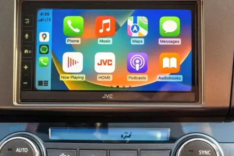 Ekran samochodu z ikonami aplikacji: Telefon, Muzyka, Mapy, Wiadomości. To jest właśnie carplay co to za technologia.