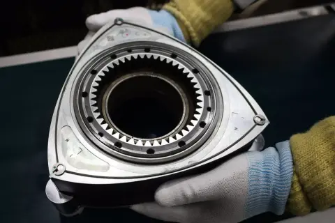 Rotor silnika Wankla, serce legendarnej Mazdy RX-3, w rękach mechanika.