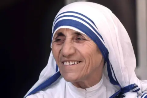 Porträt von Mutter Teresa, deren Lächeln trotz Kritik an ihrer Arbeit Wärme ausstrahlt.