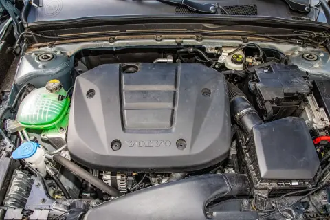 Silnik Volvo T3 z widocznym zielonym płynem w zbiorniczku i czarną osłoną z logo.