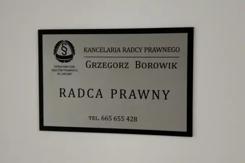 Tabliczka z napisem "Kancelaria Radcy Prawnego Grzegorz Borowik", z logo i numerem telefonu.