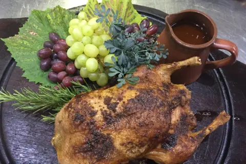 Gefüllte Ente mit Trauben und Rosmarin, serviert mit einer Sauce. Ein Festmahl, das an Schlehen Rezepte erinnert.