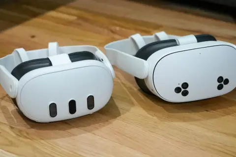 Dwa białe gogle VR Meta Quest 3 na drewnianym blacie.