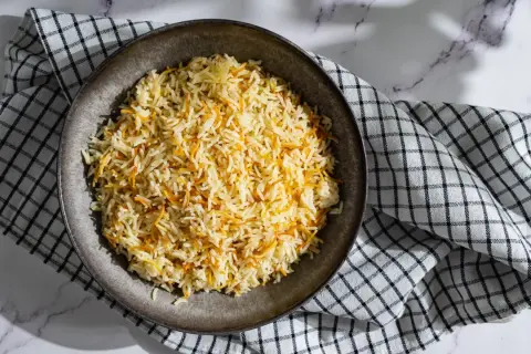 Un plat de riz libanais, parsemé de vermicelles dorés, servi sur une serviette à carreaux.