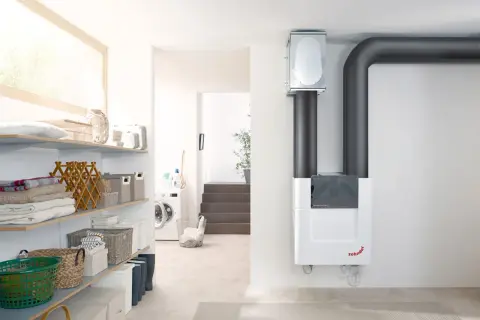 Moderne Lüftungsanlage sorgt für optimale 70 prozent luftfeuchtigkeit in der wohnung. Wäschekorb und Waschmaschine im Hintergrund.