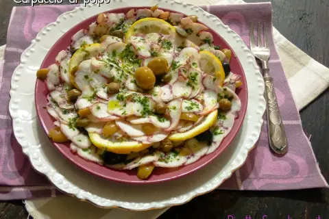Delizioso carpaccio di polpo con limone, olive e capperi, condito con erbe fresche e olio d'oliva. Un piatto leggero e saporito.