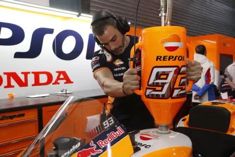 Mecánico repostando moto de competición con gasolina 100 octanos Repsol. El número 93 destaca en el depósito.