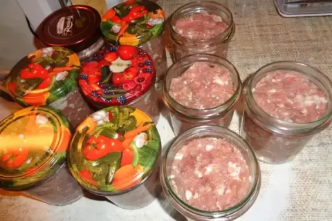 Słoiki z mielonym mięsem, gotowe do pasteryzacji. To pierwszy krok, jak zrobić kiełbasa w słoiku z galaretką.