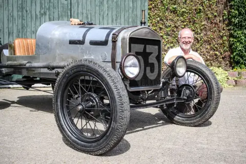 Ein Mann lächelt neben einem Oldtimer mit der Nummer 53. Wann ist ein Youngtimer steuerfrei?