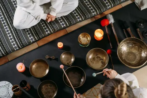 Operatore olistico stipendio: ciotole tibetane, candele e bacchette per un massaggio sonoro rilassante.