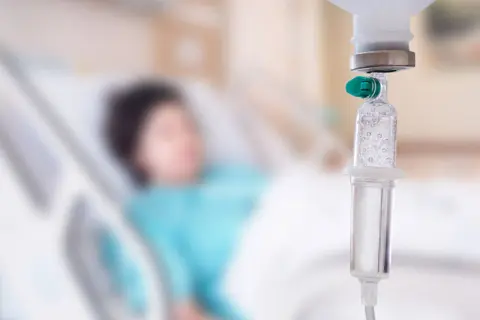 Pacjent w łóżku szpitalnym, kroplówka w zbliżeniu. Trudno określić, który dzień po chemioterapii jest najgorszy.