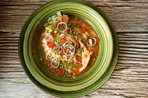Aromatyczna zupa pho z kurczakiem, z makaronem ryżowym, cebulą, chili i szczypiorkiem. Idealny przepis na rozgrzewający posiłek.