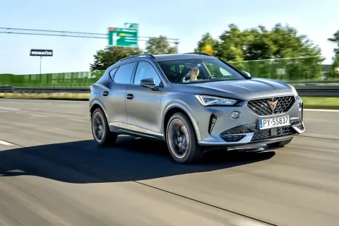 Srebrna karoseria sportowego SUV-a sunie po autostradzie.