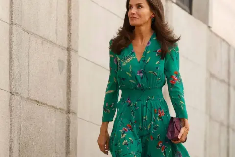 Letizia Ortiz luce un elegante vestido verde estampado con flores, portando un bolso morado.
