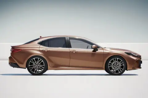 Elegancka, brązowa Toyota Camry 2.5 Hybrid w profilu, prezentująca nowoczesny design i dynamiczną sylwetkę.