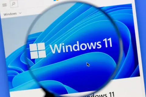 Lupa powiększa logo Windows 11, sugerując rozwiązanie problemu z wolnym komputerem.
