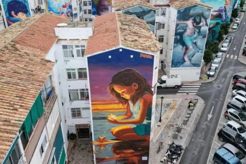 El **Soho Viertel Málaga** se llena de arte con murales gigantes. Una niña mira una estrella en un atardecer mágico.